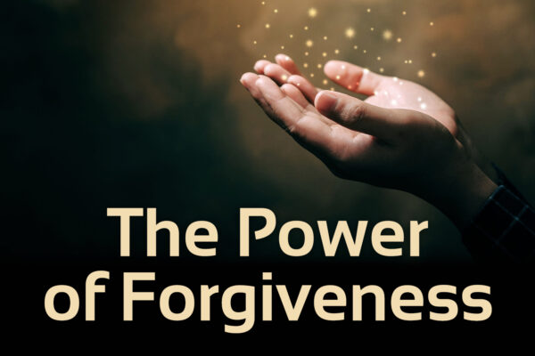 Dark background with two hands reaching out, gold specks coming from hands. Underneath there is text that says 'The power of forgiveness'