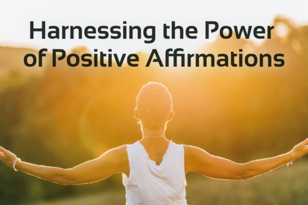 'harnessing the power of positive affirmations' text with image of person with open arms at sun set